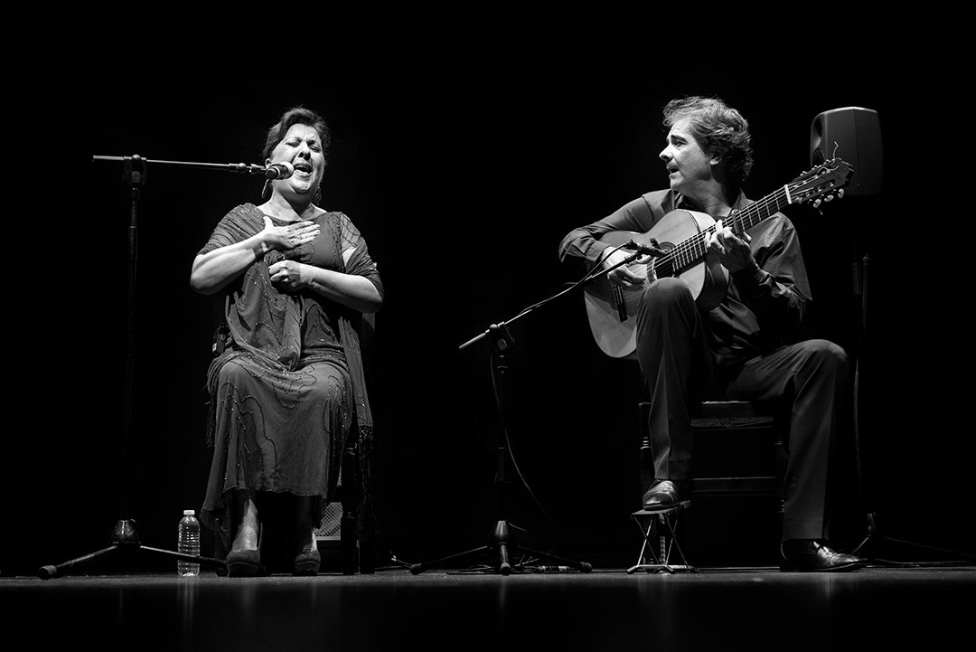 Una cantante y un guitarrista actúan juntos.